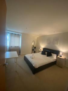 a bedroom with a large bed and a table at 2 bedroom luxury apartment Birmingham city centre in Birmingham