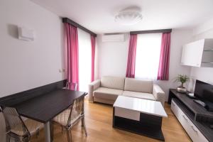 ein Wohnzimmer mit einem Sofa und einem Tisch in der Unterkunft Apartments Villa Novak 1 in Okrug Donji