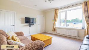 a living room with a couch and a tv at Mardon Holiday Home STL Licensed in Inverness