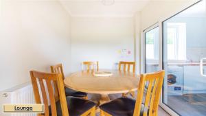 una sala da pranzo con tavolo e sedie in legno di Mardon Holiday Home STL Licensed a Inverness