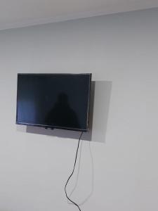 uma televisão de ecrã plano em cima de uma parede em Departamento de Caro em Tandil