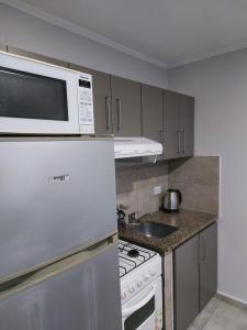 uma cozinha com um micro-ondas branco por cima de um fogão em Departamento de Caro em Tandil
