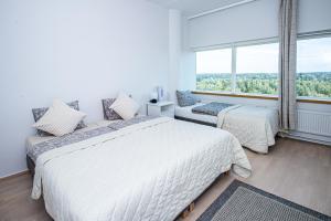 1 Schlafzimmer mit 2 Betten und einem großen Fenster in der Unterkunft Flexi Homes Itäkeskus in Helsinki