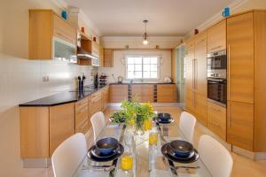 a kitchen with a glass table and white chairs at Private Deluxe 3BD Villa Pool Wi-Fi AC BBQ in Albufeira