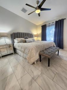 The Villa Orlando@College Park. Sleeps16 في أورلاندو: غرفة نوم بسرير كبير مع مروحة سقف