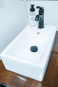 a white sink with a bottle of soap on it at Snodgrass Suite 301, Hyland Hotel in Palmer