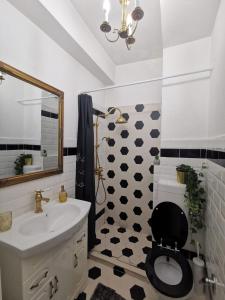 ein Badezimmer mit einem WC, einem Waschbecken und einem Spiegel in der Unterkunft WOW INN COTROCENI in Bukarest