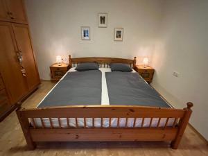 a bedroom with a wooden bed with two night stands at Haus am Wald in Marktschellenberg