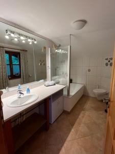 a bathroom with a sink and a tub and a toilet at Haus am Wald in Marktschellenberg