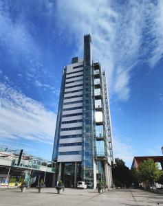 um edifício de vidro alto com um carro em frente em Flexi Homes Itäkeskus em Helsinque