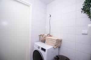uma lavandaria com uma máquina de lavar roupa e toalhas em Flexi Homes Itäkeskus em Helsinque