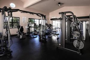 a gym with several tread machines in a room at Stunning 3BR Condo with Ocean Views, Golf Course & Resort Amenities in Cabo San Lucas