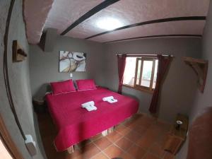 a bedroom with a red bed with two towels on it at Finca Momota Salento in Salento