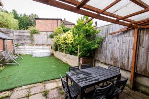 a patio with a table and chairs in a backyard at Windsor House 3 Bedrooms Sleeps 8 in Manchester