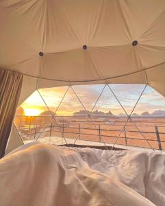 a white bed with a view of a field at Space camp in Wadi Rum