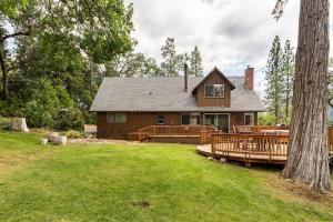a house with a large yard with a wooden deck at Sequoia Retreat- Spacious Cabin, Hot tub, & Sundeck in Ponderosa +60 photos