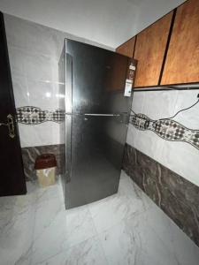 een badkamer met een zwarte koelkast in een kamer bij عجمان كورنيش in Ajman 