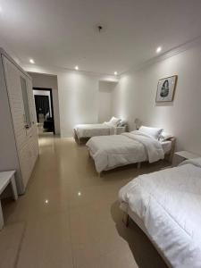 una habitación de hotel con 3 camas en una habitación en عجمان كورنيش, en Ajman