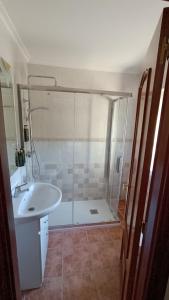 y baño con ducha y lavabo blanco. en Casa Elisa Monegro., 