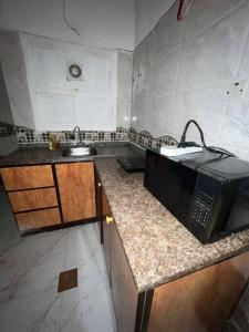 una cocina con fregadero y microondas en una encimera en عجمان كورنيش, en Ajman