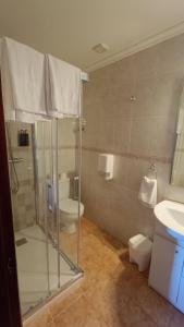 uma casa de banho com um chuveiro, um WC e um lavatório. em Casa Elisa Monegro. 