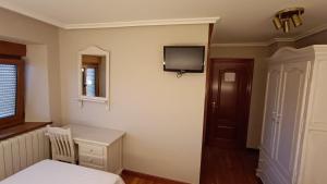 a bedroom with a bed and a tv on the wall at Casa Elisa Monegro. in Monegro