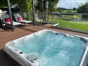 eine Whirlpool-Badewanne auf einer Terrasse mit Aussicht in der Unterkunft The DeerView Lodge in Cardiff