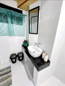 bagno con lavandino e specchio di Simple Room in a Transient House a Baguio