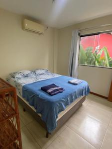 sypialnia z łóżkiem z niebieską pościelą i oknem w obiekcie Blue House Barra grande w mieście Barra Grande