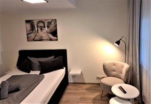 ein kleines Schlafzimmer mit einem Bett und einem Stuhl in der Unterkunft Hotel Zum Postkutscher in Cottbus