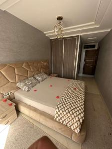 a bedroom with a large bed with red flowers on it at Appartement de Lux Hay Al MATAR in Nador