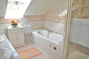 een badkamer met een bad, een wastafel en een douche bij Chambres chez l'habitant - Chez Nico & Belen 