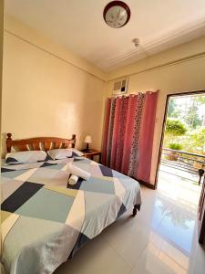 1 dormitorio con 1 cama, ventana y reloj en DIAKOPES INN en Puerto Princesa