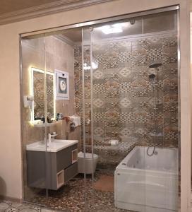 een badkamer met een douche, een wastafel en een bad bij Eileen Hotel Cairo in Caïro
