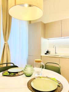 ミラノにあるTarra Luxury Suiteのダイニングルームテーブル(緑と白の皿付)