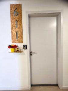 une porte blanche avec un panneau sur le mur dans l'établissement Departamento 2do y 3er anillo, à Santa Cruz de la Sierra