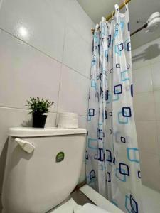 a bathroom with a toilet and a shower curtain at Hermosa habitación con terraza y vista al pastaza in Baños