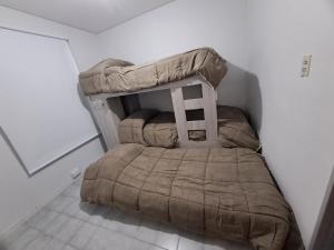 a small bedroom with a bed in the corner at Depto 75m 2 dormitorios Frente al Parque Central con Cochera en el Centro denMendoza in Mendoza