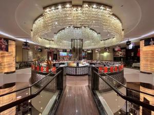 a lobby with a large chandelier and a restaurant at Yue Yang Hotel in Yueyang