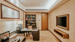 een woonkamer met een tv en een bank en een tafel bij Yue Yang Hotel in Yueyang