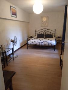 Schlafzimmer mit einem Bett, einem Tisch und einem Ventilator in der Unterkunft Chambres d'hôtes du Péras in Saint-Jean-du-Gard