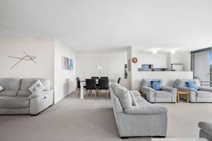 a living room with two couches and a dining room at Unit 8 26 Jubilee Esplanade in Yaroomba