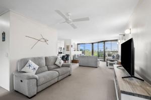 a living room with a couch and a tv at Unit 8 26 Jubilee Esplanade in Yaroomba