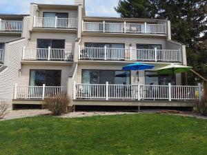 an apartment building with two umbrellas in front of it at The Grand Getaway - Gorgeous And Great Location! in Traverse City