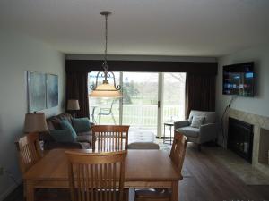 a living room with a table and chairs and a couch at The Grand Getaway - Gorgeous And Great Location! in Traverse City