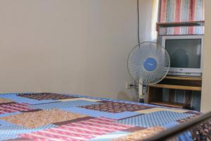 a room with a bed with a fan and a television at Homestay Matagalpa in Matagalpa
