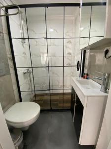 a white bathroom with a toilet and a sink at Kadıköy Linda Hotel in Istanbul