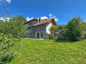 a house on a hill with a green yard at Idyllische Ferienwohnung in der Oberpfalz in Rötz