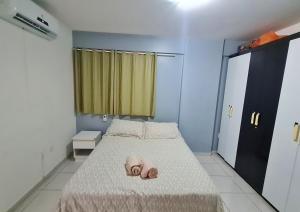 1 dormitorio con 1 cama con 2 zapatillas en Apartamento Monte Paradiso, en Maceió