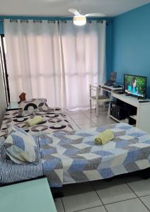 a bedroom with a bed and a desk with a computer at Apartamento Monte Paradiso in Maceió